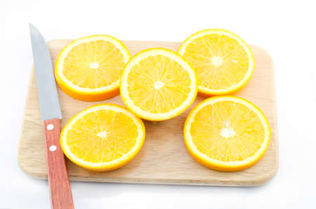 Pieces of Orange and knife on a cutting wooden boardの写真素材