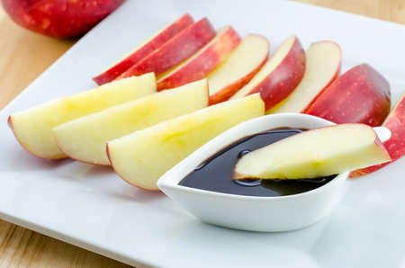 Apples with chocolate on wooden tableの写真素材