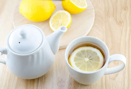 Cup of lemon tea and lemon slice on wooden tableの写真素材