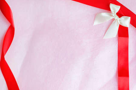 Rosy pink paper texture background with ribbon and bowの写真素材