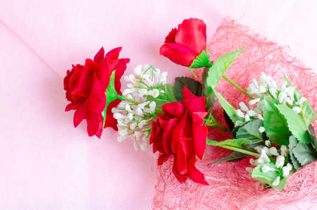 Artificial rose bouquet on pink backgroundの写真素材