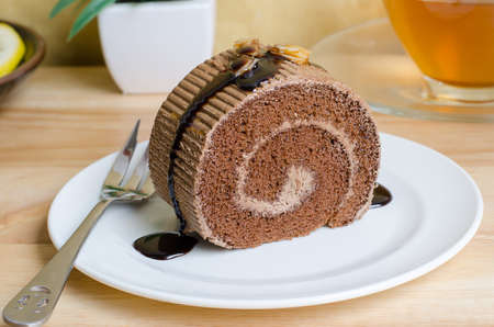 Chocolate roll cake with caramel and chocolate sauceの写真素材