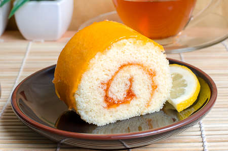 Orange roll cake in plate with orange sliceの写真素材
