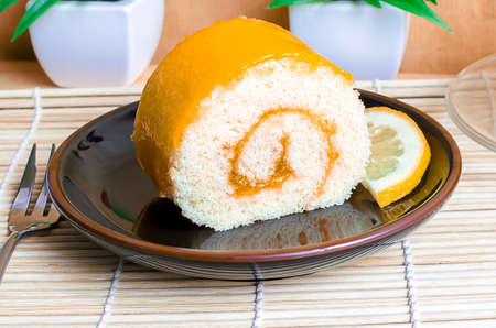 Orange roll cake in plate with orange sliceの写真素材