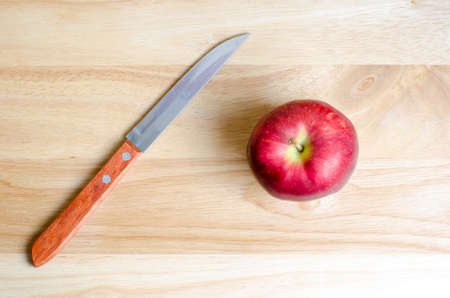 Red apple and knife on wooden tableの写真素材
