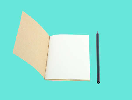 Notebook from recycle paper and black pencil isolate on blueの写真素材