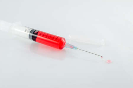 Medical syringe with drop on white backgroundの写真素材