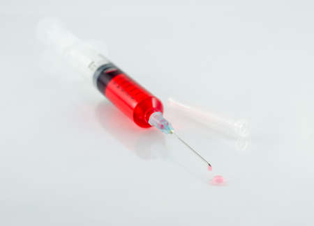 Medical syringe with drop on white backgroundの写真素材