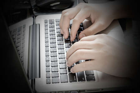 Close up male hands typing on laptop with vignette toneの写真素材