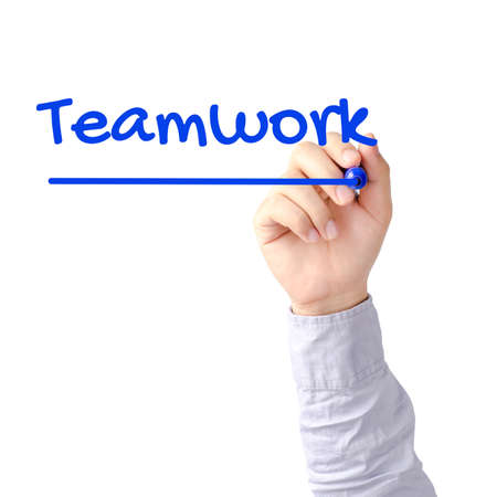 Right hand of young business man writing Teamwork with blue marker on transparent boardの写真素材