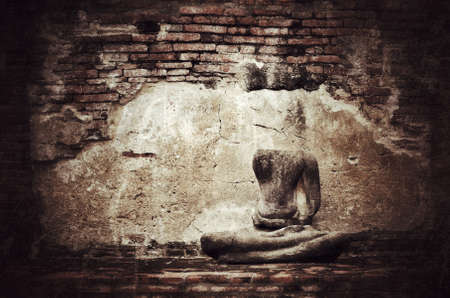 Old broken Buddha statue on grunge brick wall background with vintage and vignette tone - Civilization collapseの写真素材