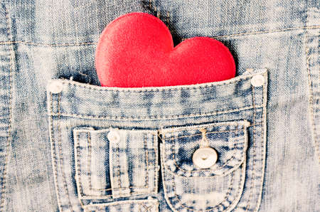 Red heart shape in jeans bag with vintage toneの写真素材