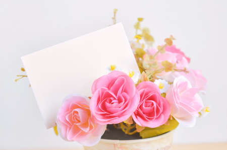 Pastel Coloured Artificial Pink Rose Wedding Bridal Bouquet in flower pot and white paper card with soft vintage toneの写真素材