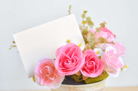 Pastel Coloured Artificial Pink Rose Wedding Bridal Bouquet in flower pot and white paper card with soft vintage toneの写真素材