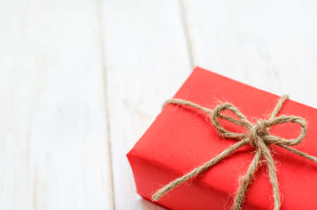Red box gift with brown rope on white vintage wooden tableの写真素材