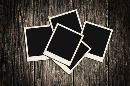 Three instant photo frame on old dirty wooden background with vintage and vignette tone