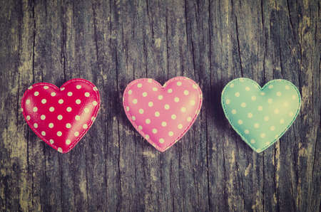 Retro heart with white dot pattern on old wooden table with vintage and vignette tone