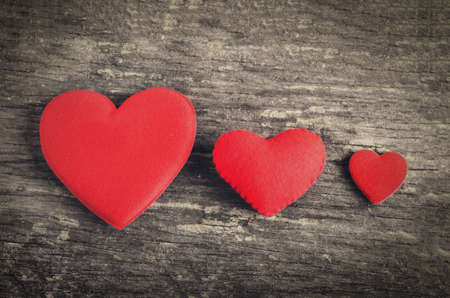 Red heart with different size on wooden table with vintage and vignette toneの写真素材
