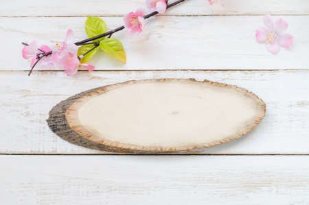 Blank wooden sign on white vintage wooden background with pink artificial flowerの写真素材