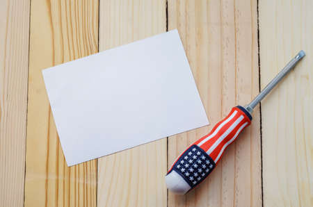 Screwdriver with flag of The United States of America pattern on wooden table with blank greeting card paper - Labor Dayの写真素材