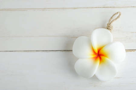 Spa aromatherapy soap with Plumeria flower shape on white vintage wooden tableの写真素材