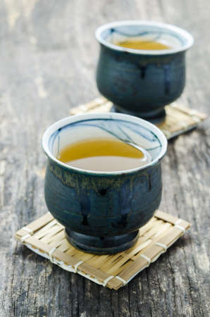 Cup of Japanese green tea on old wooden tableの写真素材