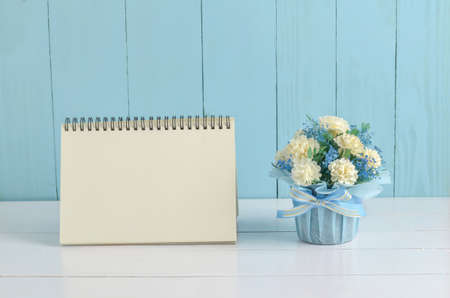 Blank desk calender card paper and beautiful Jasmine flower bouquet with blue ribbon bow on white and blue wooden background - Jasmine is the symbol of Mother's Day in Thailand.の写真素材