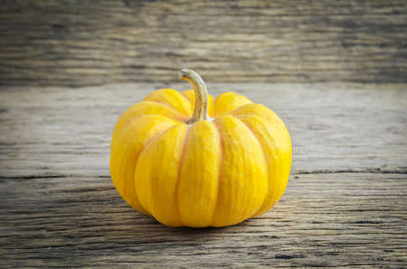 Close up of small pumpkin on wooden table background with vignette colorの写真素材
