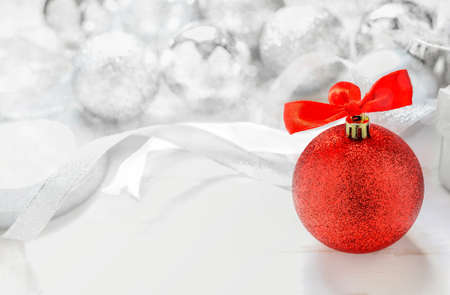 Christmas Background - Red glitter christmas ball with red ribbon bow on white background with silver glitter ball and bokeh lightの写真素材