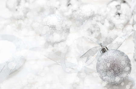 Silver Christmas ball with ribbon on white spakles bokeh light background, Christmas backgroundの写真素材