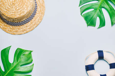 Straw hat with green leaves and lifebuoy on blue wooden background, Summer backgroundの写真素材