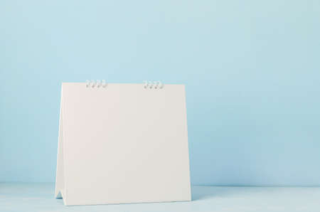 Blank desk calendar on white and blue wooden background, Blank notebook on wooden tableの写真素材