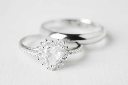 Close up of couple wedding diamond rings on white wooden backgroundの写真素材