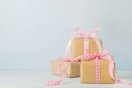 Group of brown gift box with pink ribbon bow on blue wooden background with soft vintage toneの写真素材