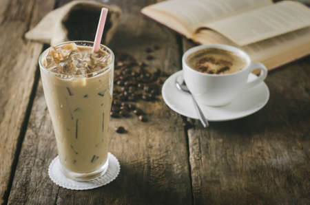 Close up of Iced Coffee on wooden table with cup of lattee and coffee beansの写真素材