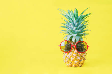 Pineapple with red sunglasses on yellow background - Summer backgroundの写真素材