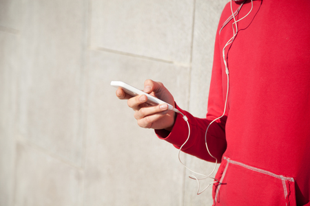 Close-up of young beautiful female hands using phone app while resting after everyday workout. Woman athlete runner taking a break and using smartphone. Copyspaceの写真素材
