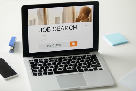 Open laptop on the office desk, job search title on the screen, close up. Human resources, HR concept photoの写真素材