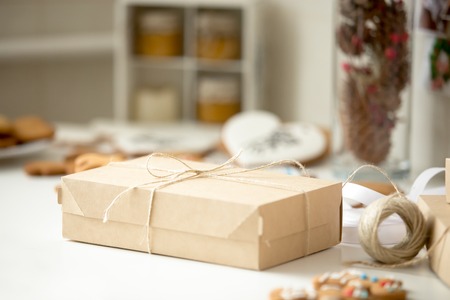 Cardboard box, postal parcel wrapped in brown kraft paper tied with a rope, ready for delivery....
