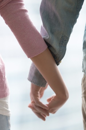 Close up of couple holding hands, female and male hands together, expressing happy relationships, family support, travelling together, loving couple, romantic feelings, sharing love, good and badの写真素材