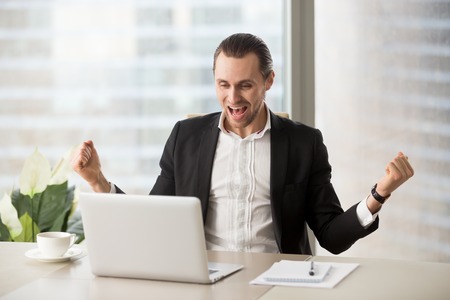 Happy businessman excited because of great deal, achievement, company success. Young entrepreneur...