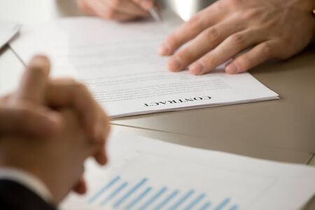 Businessman signing contract at meeting with partner, male hand putting signature on document, venture investing in startup, concluding consulting risk agreement, entering partnership, close up viewの写真素材