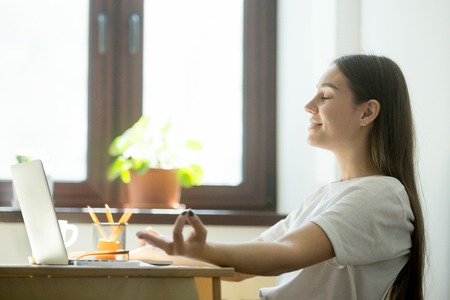 Female employee relaxing in office during a coffeebreak. Office yoga concept.の写真素材