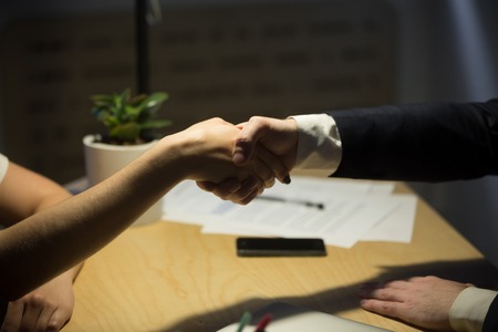 Two businesspeople shake hands to seal a deal, recruiter employing new staff member, human resources...
