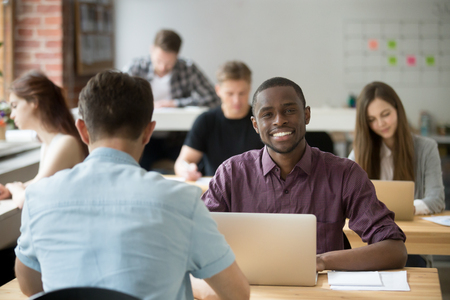 Happy african american worker smiling looking at camera satisfied with company market success, high income and good results. Excited black student pleased with work evaluation. Education, outsourcingの写真素材
