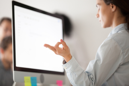 Close up of concentrated calm female employee relaxing meditating at work, taking break from work practicing yogaの写真素材