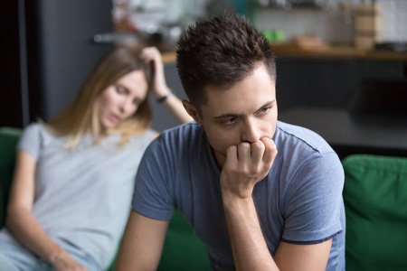 Upset frustrated boyfriend thinking of family conflicts after fight with girlfriend, sad thoughtful husband disappointed in bad marriage relationships tired or problems and disagreements with wifeの写真素材