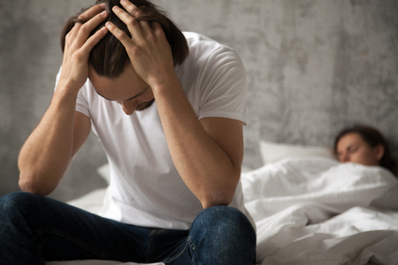 Frustrated boyfriend feel despair fight with girlfriend, upset husband sit on bed thinking of relationship issues or divorce, man consider breaking up with beloved woman after cheating, not forgivingの写真素材