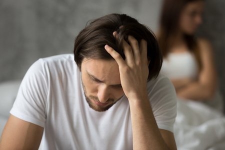 Close up of upset desperate man thinking about relationship problems, worried husband considering break up with beloved girlfriend after cheating, young spouses feel upset after fight or quarrelの写真素材