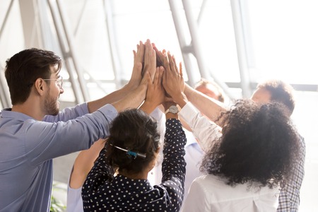 Diverse business team associates office workers group giving high five together as concept of...